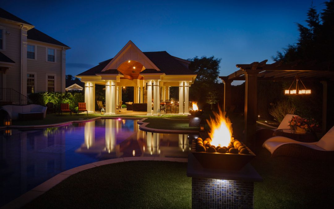 Outdoor pavilion with a bar and gas fireplace overlooking the pool
